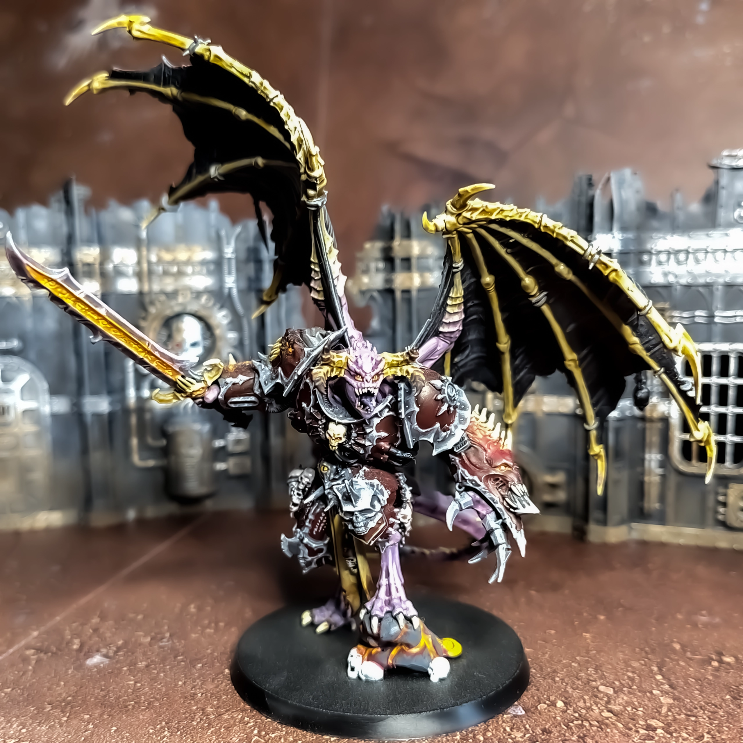 A photograph of a Demon Prince model with silver non-metallic metal armour trim, dark red armour and red glowing runes on the sword.